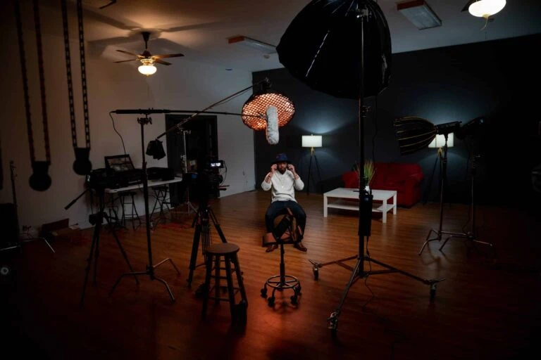 Man sitting in video recording studio with blackmagic equipment as a cinematographer